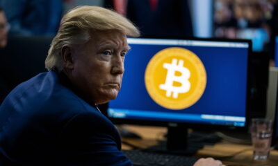 preisdent donald trump, back to the viewer, looking at a computer screen with the bitcoin logo on it