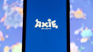 Axie Infinity (AXS) logo appears on a mobile phone screen.