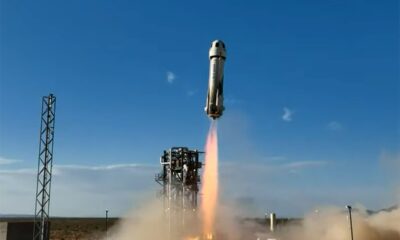 a white rocket launches into a blue sky